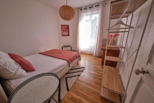 une chambre avec un lit avec deux chaises et une étagère dans l'établissement Le Voltis, à Épernay