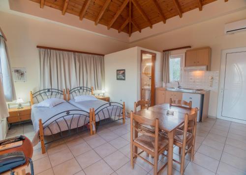 a bedroom with a bed and a table and a kitchen at Apartments Hotel & Studios, Xifoupolis in Monemvasia