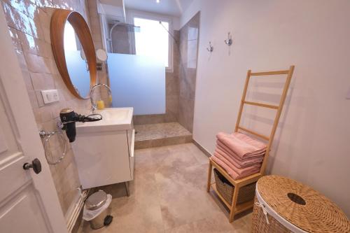 une salle de bain avec un lavabo et un miroir dans l'établissement Le Voltis, à Épernay