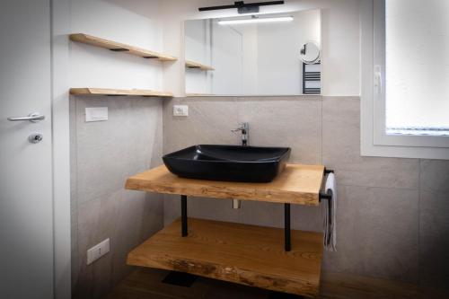 a bathroom with a black sink on a wooden counter at Cristal apartments in Piove di Sacco