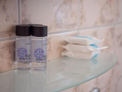two bottles on a glass shelf in a bathroom at Apartments Hotel & Studios, Xifoupolis in Monemvasia