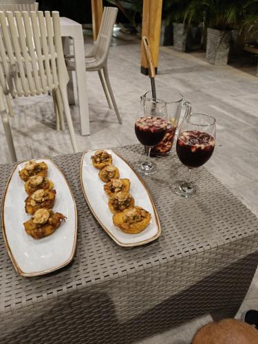 a table with two plates of food and two glasses of wine at Hotel Aqua House in Tubará