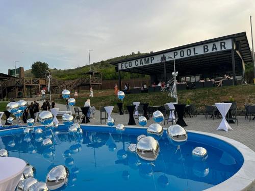 a pool with silver chairs and a pool bar at Eco Camp Lake Mladost in Veles