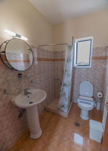 a bathroom with a sink and a toilet and a mirror at Apartments Hotel & Studios, Xifoupolis in Monemvasia