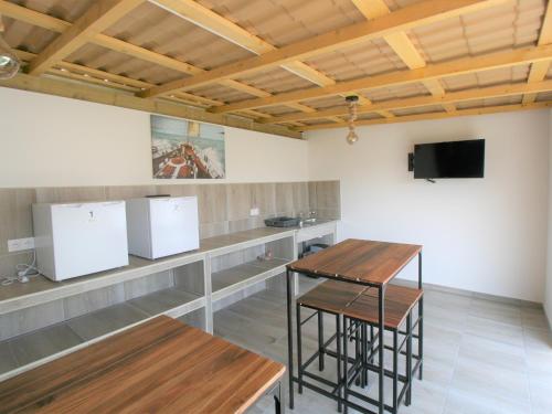 Cette chambre dispose d'une table, de deux tabourets et d'une télévision. dans l'établissement Charmant logement rénové 2/3 pers, jardin commun, 750m plage, 850m centre-ville - FR-1-22-350, à La Tranche-sur-Mer