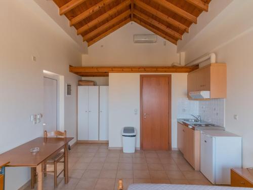 a kitchen with a table and a wooden ceiling at Apartments Hotel & Studios, Xifoupolis in Monemvasia