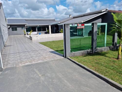a house with a driveway in front of a building at Casa Alto Padrão Perto da Praia C/ Piscina Grande in Guaratuba