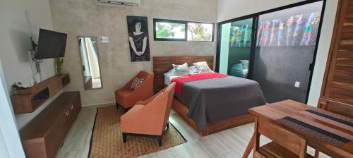 a room with a bed with a table and a chair at Tu Departamento en Mahahual in Mahahual