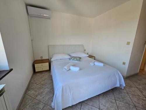 a bedroom with a white bed with two towels on it at Rooms Tanja Lovran in Lovran