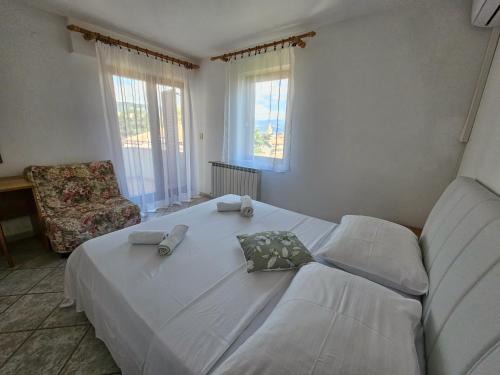 a bedroom with a large white bed and a couch at Rooms Tanja Lovran in Lovran