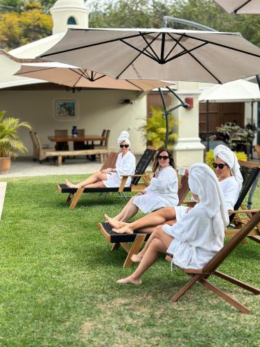 a group of women sitting on chairs under an umbrella at Quinta Los Caballos in Ajijic