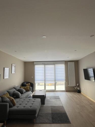 a living room with a couch and a table at AppartHôtel Elite Spa in Forbach