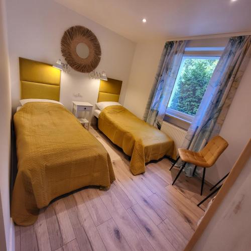 a hotel room with two beds and a window at Carpe Diem Lakeside Suite Apartments in Szczecin