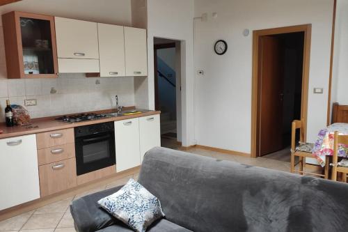 a living room with a couch and a kitchen at Appartamento vacanza Coredo Trentino in Coredo