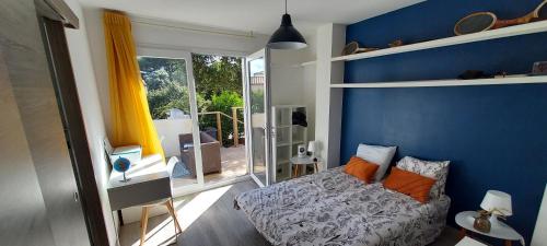 - une chambre avec des murs bleus et un lit avec des oreillers orange dans l'établissement Villa Garrigue - piscine, parking, maison entière, à Beaulieu