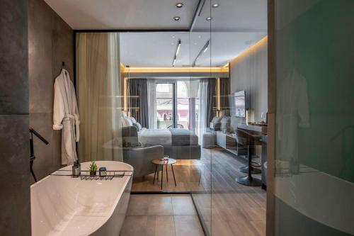 a bathroom with a sink and a living room at Aristotelian Virtues - Agapi in Thessaloniki
