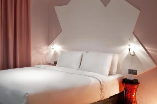 1 cama blanca con almohadas blancas en una habitación en Melange Boutique Hotel Bukit Bintang, en Kuala Lumpur