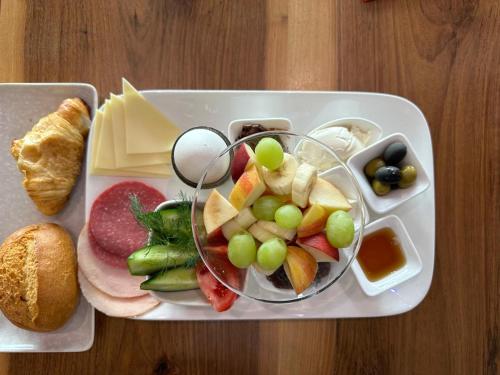 a tray of food with grapes and cheese and bread at Hotel Königshof The Arthouse in Cologne