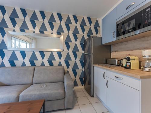 a living room with a couch and a kitchen at Appartement T2 refait à neuf - 4 pers - Terrasse Ouest - Proche centre - Chiens OK - FR-1-521-237 in Biscarrosse