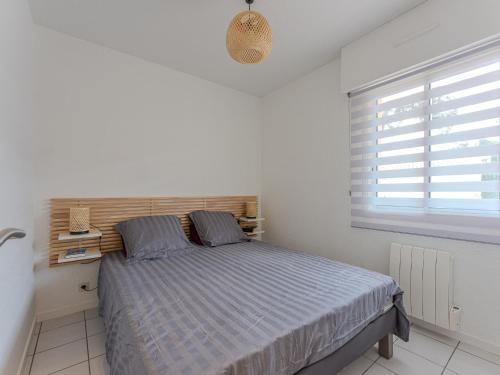 a bedroom with a bed and a window at Appartement T2 refait à neuf - 4 pers - Terrasse Ouest - Proche centre - Chiens OK - FR-1-521-237 in Biscarrosse