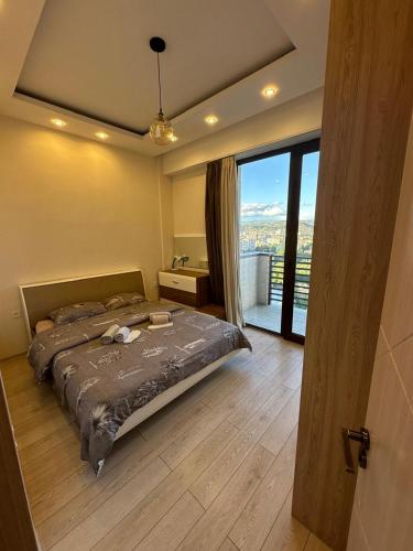 a bedroom with a large bed and a large window at Apartment in the center Tbilisi in Tbilisi City