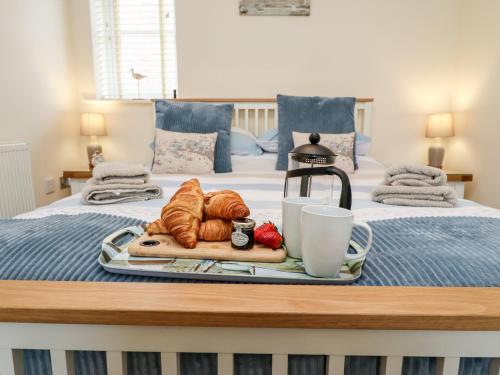 un vassoio di croissant e cornetti su un letto di Bay Cottage a Filey