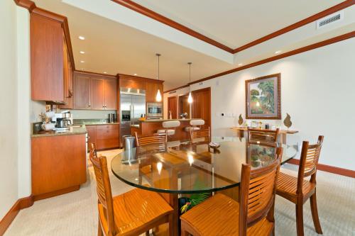 a kitchen and dining room with a glass table and chairs at Hilton Pool Pass Included, Kolea - Luxe 2BR Villa Steps to Beach Pool HotTub Gym in Waikoloa