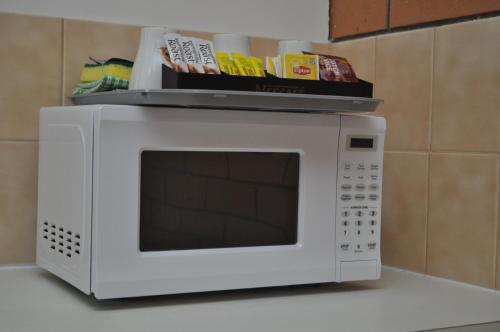 a white microwave on a kitchen counter with food on top at Keith Motor Inn in Keith