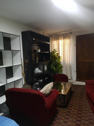 a living room with two red couches and a table at la casa de los amigos in Arequipa