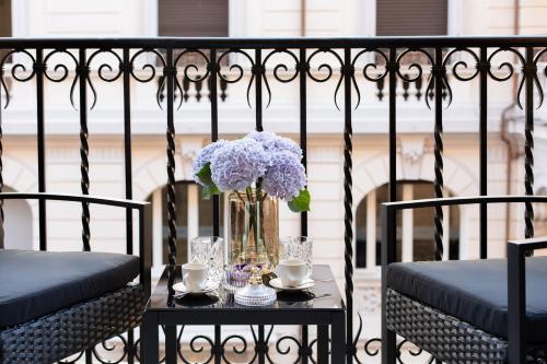 a table with a vase of flowers on a balcony at Belli Boutique Guest House in Rome