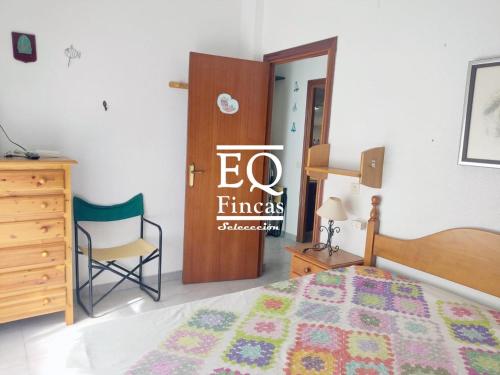 Un dormitorio con una cama, un escritorio y una silla. en Punta house, en Punta Umbría