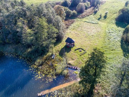 an aerial view of a house next to a body of water at Šnekučių kaimas in Miežonys