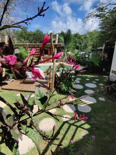 a garden with pink flowers and a swimming pool at Tu Departamento en Mahahual in Mahahual