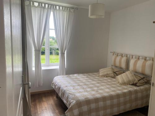 une chambre avec un lit et une fenêtre dans l'établissement Petite maison dans le Morvan, à Luzy
