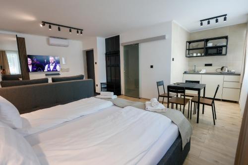 a bedroom with a large bed and a living room at Gyulai Várpark Apartman 2 in Gyula