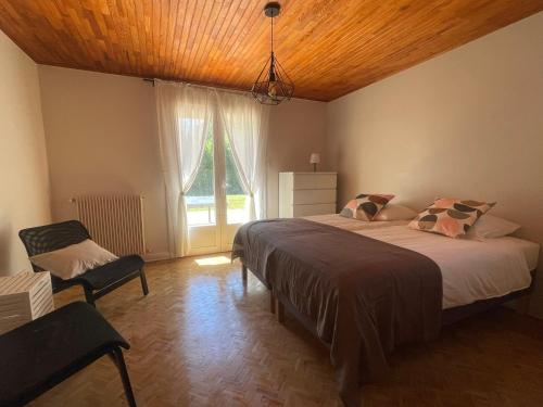 une chambre avec deux lits et une chaise et une fenêtre dans l'établissement Villa Kéana avec Piscine en Sud Ardèche, à Lachapelle-sous-Aubenas