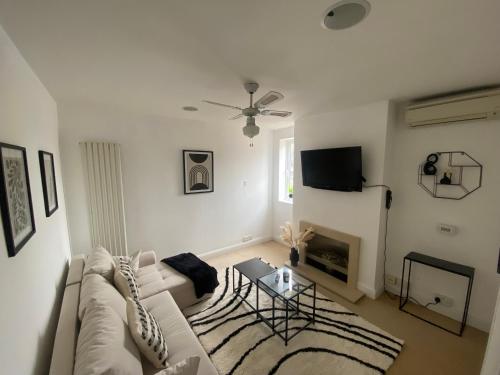 a white living room with a couch and a table at Ipswich town centre two bed apartment in Ipswich