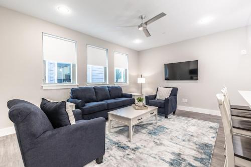 a living room with two couches and a tv at Magnolia District Modernism in Fort Worth