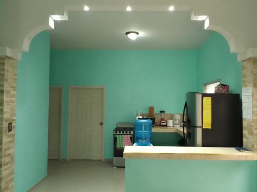 a kitchen with blue walls and a refrigerator at Casa huésped in Juticalpa