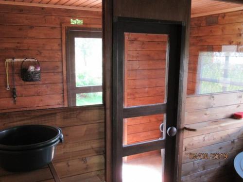 an open door of a log cabin with a tub at Maatilamajoitus in Ylihärmä