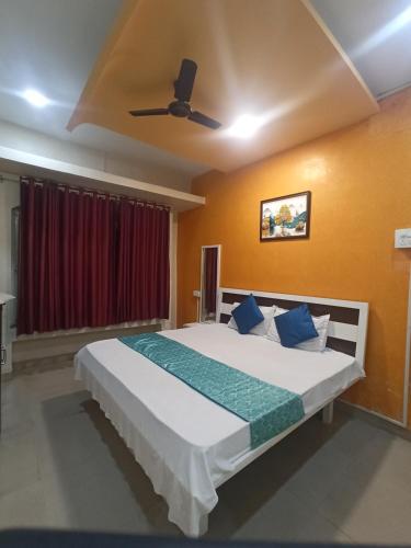 a bedroom with a large bed with blue pillows at Malwade Motel in Pune
