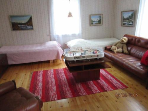 a living room with a couch and a red rug at Maatilamajoitus in Ylihärmä