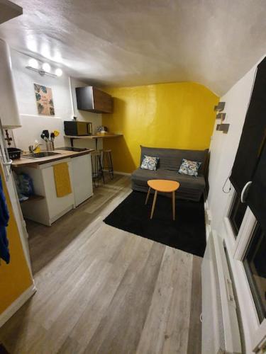 un petit salon avec un canapé et une table dans l'établissement Joli studio au coeur d'Orléans et bords de Loire, à Orléans