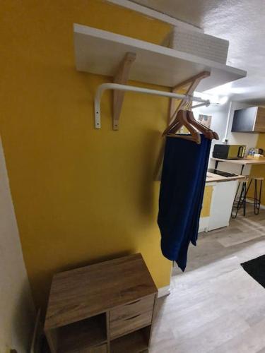 une chambre avec une veste bleue suspendue sur un mur dans l'établissement Joli studio au coeur d'Orléans et bords de Loire, à Orléans