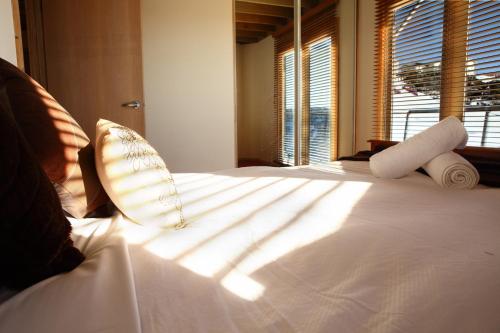 a bedroom with a bed with white sheets and a window at Sanki in Mount Hotham