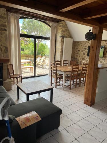 un salon avec une table et des chaises dans l'établissement Maison charmante à Maleville avec jardin privé et parking.B, à Maleville