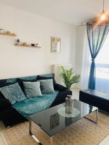 un salon avec un canapé et une table dans l'établissement Confort appart entre Paris & Aéroport Charles de Gaulle, à Goussainville