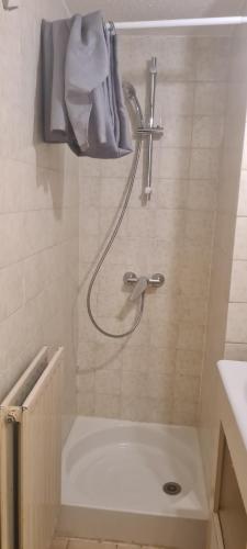 a shower in a bathroom with a towel on the wall at 2 pièces en rez- de -jardin in Saint-Raphaël