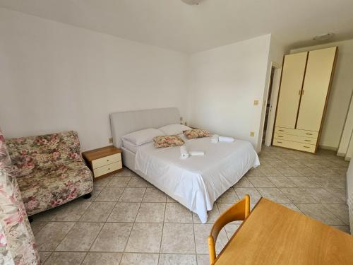 a bedroom with a bed and a chair and a table at Rooms Tanja Lovran in Lovran