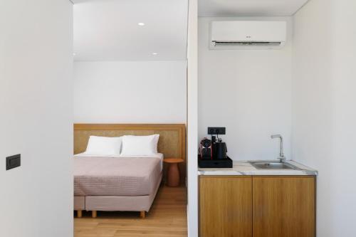 a bedroom with a bed and a sink in a room at NOIMA Casa Unico in Megalochori